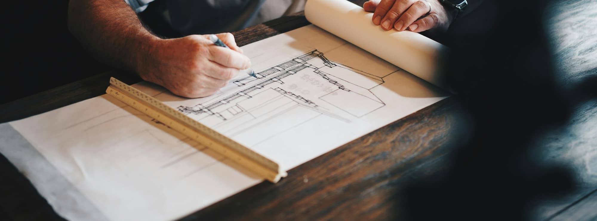 Construction drawings being worked through at an estimating desk.